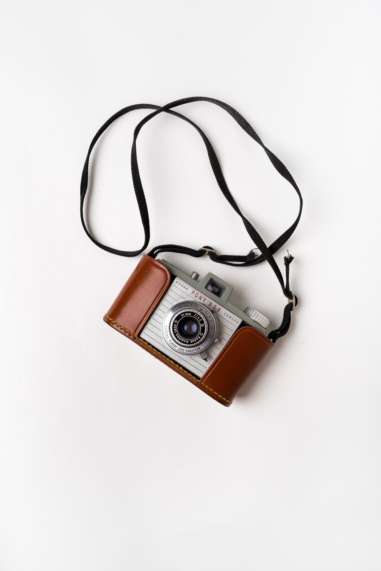 Aparat fotograficzny Kodak ze skórzanym etui i paskiem w stylu vintage